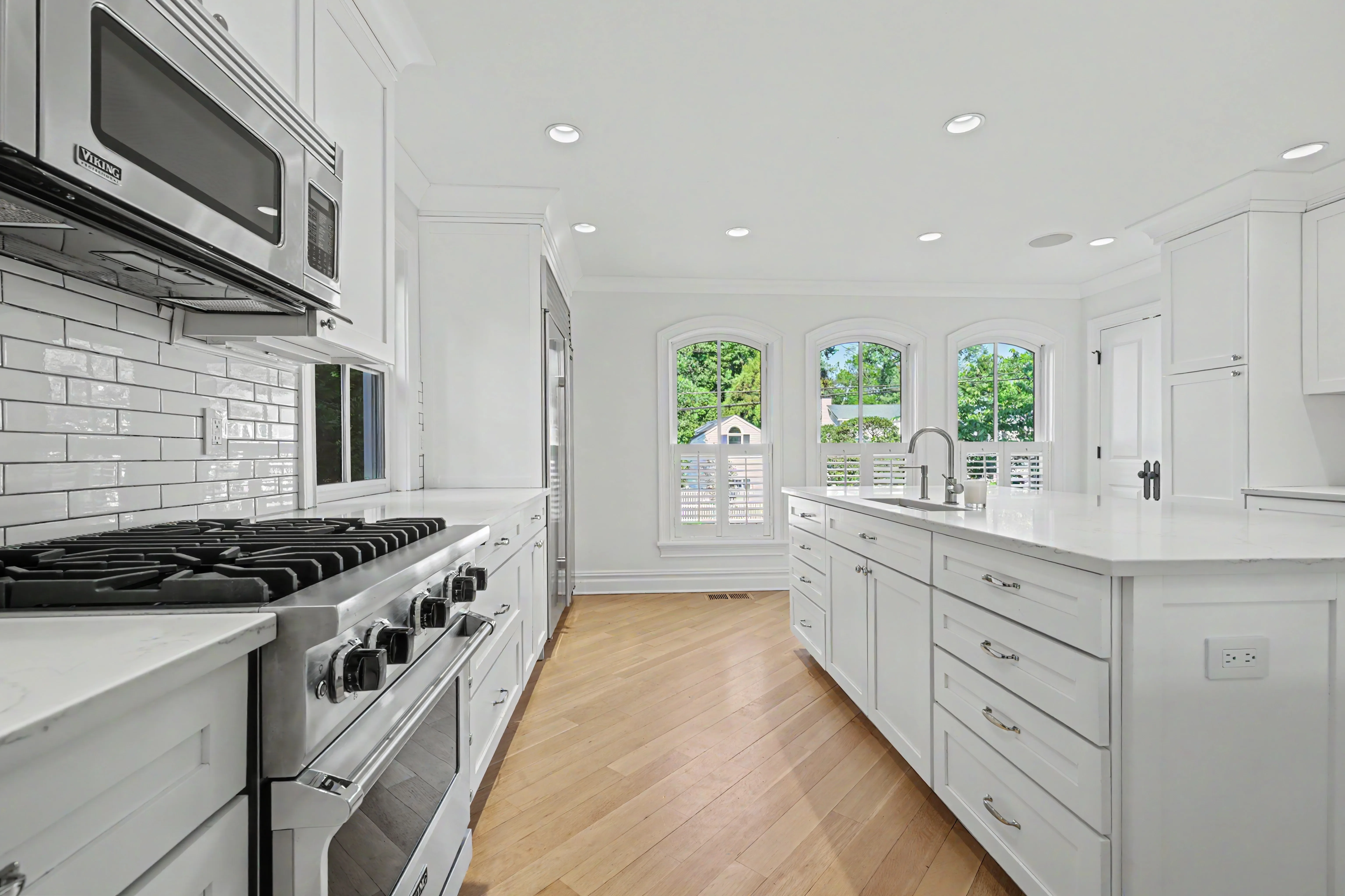 White kitchen with Viking range and arched windows — window-balanced interior, real estate photography Westchester County NY