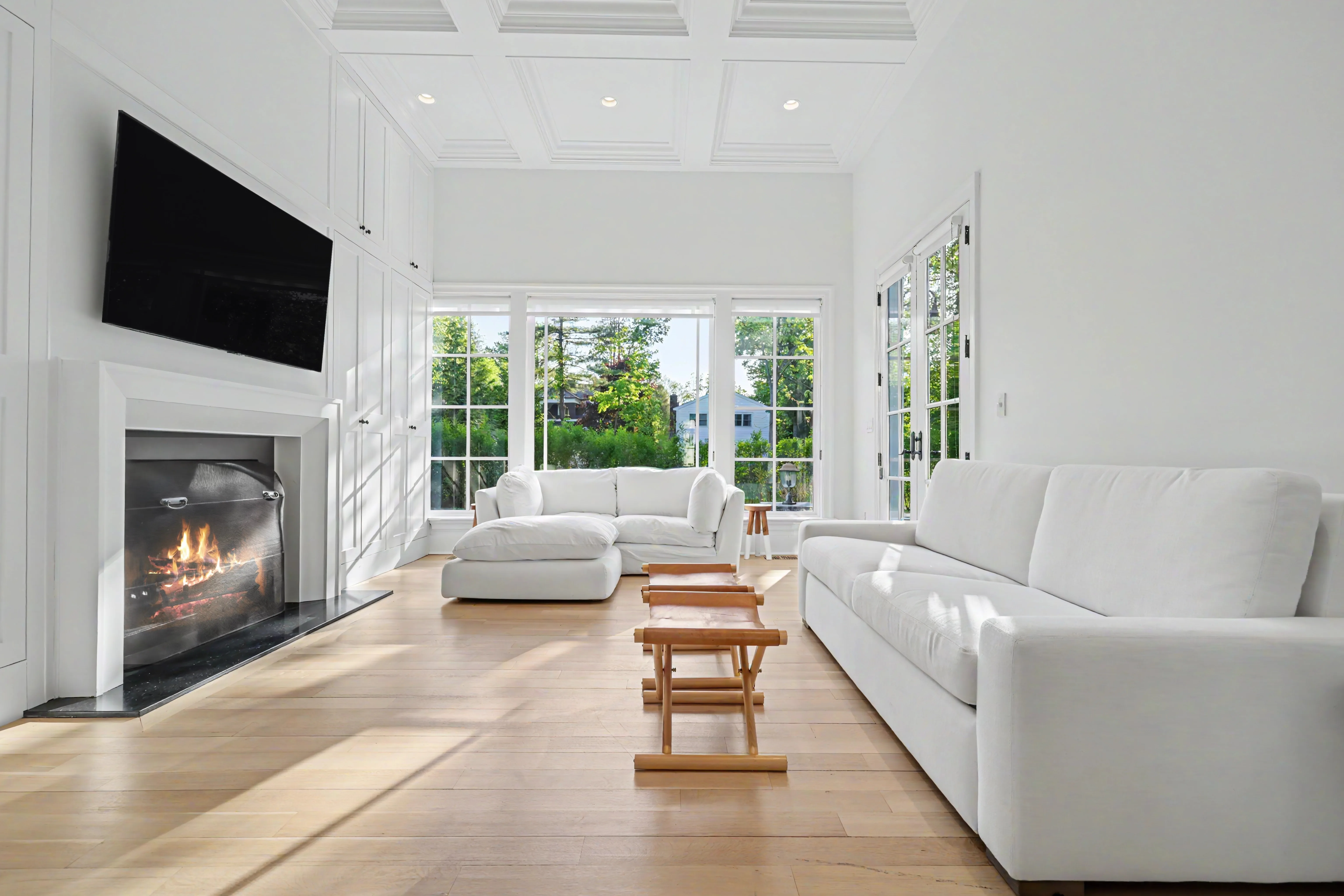 Same living room after post-production — TV reflection removed, fireplace digitally lit
