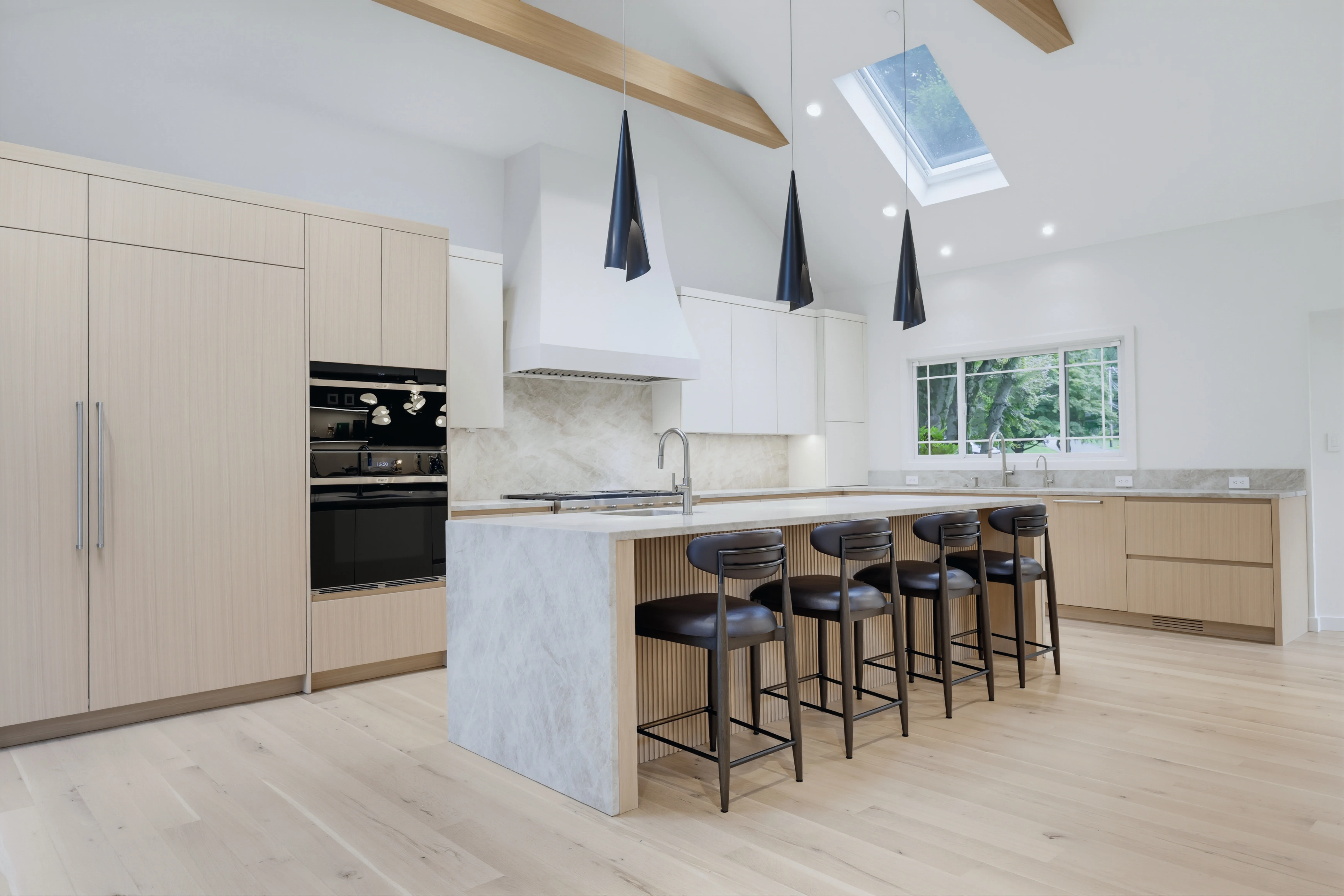 Vaulted kitchen with waterfall marble island as shot with standard editing — before premium cinematic conversion